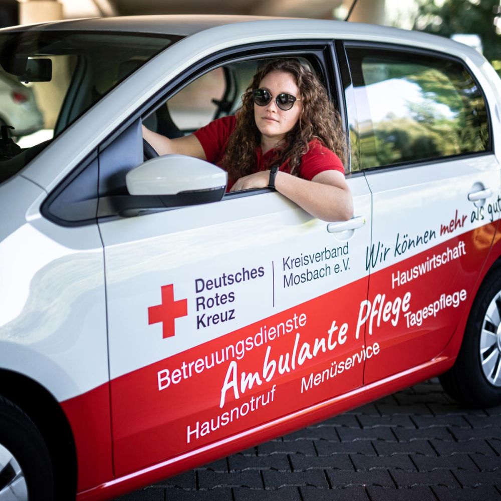 Mitarbeiterin im beklebten Auto
