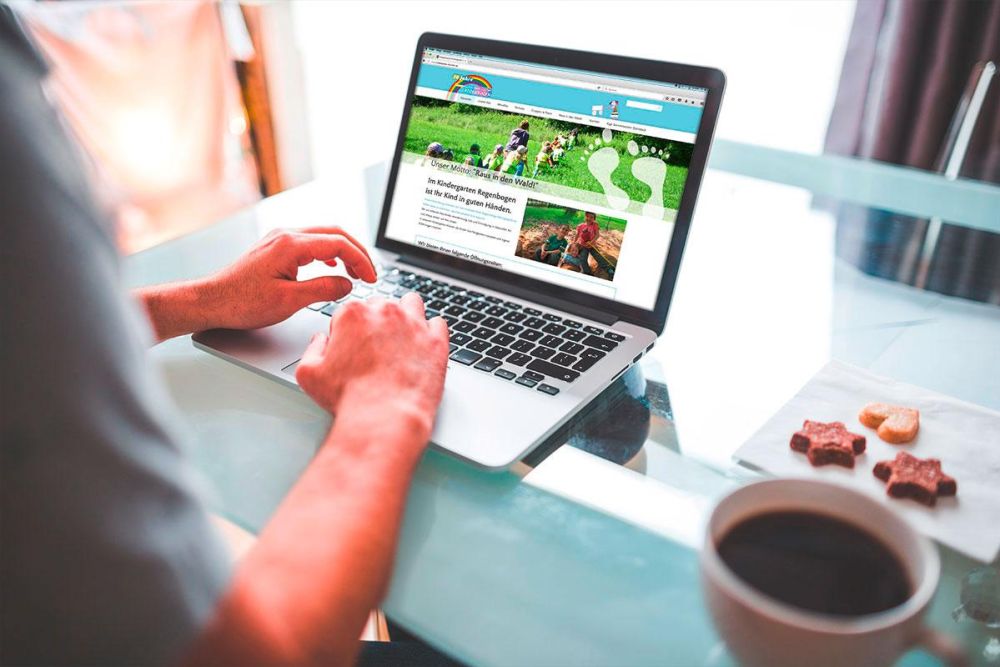 Jemand besucht die Webseite Kindergarten Regenbogen auf einem Laptop