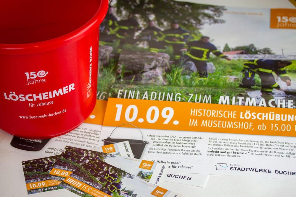 Eimer, Plakate und Flyer für die Mitmachaktion Löscheimerkette zum Jubiläum der Feuerwehr Buchen