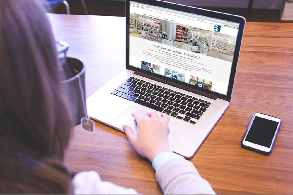 Frau am Laptop hat die Webseite von Apothekenbau Böhrer geöffnet