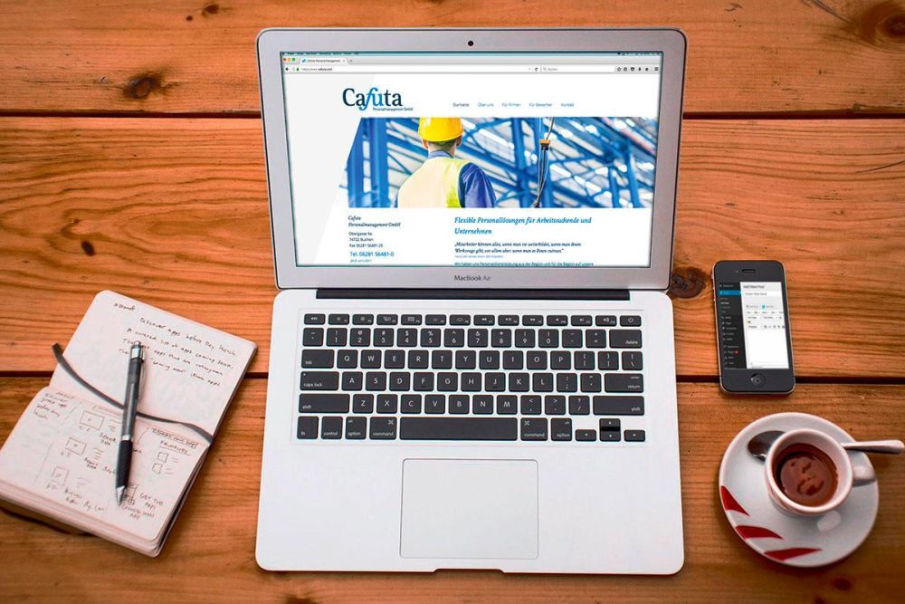 Cafuta Webseite auf einem MacBook auf einem Holztisch
