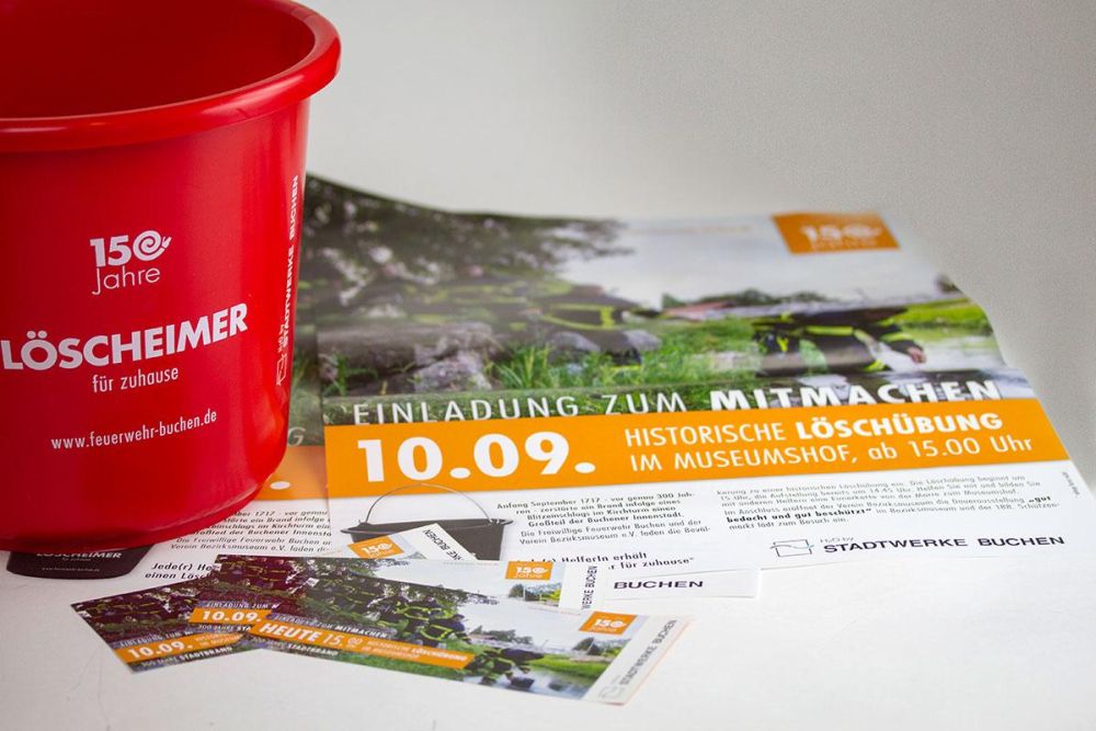 roter Löscheimer und Plakate im Corporate Design der Feuerwehr Buchen