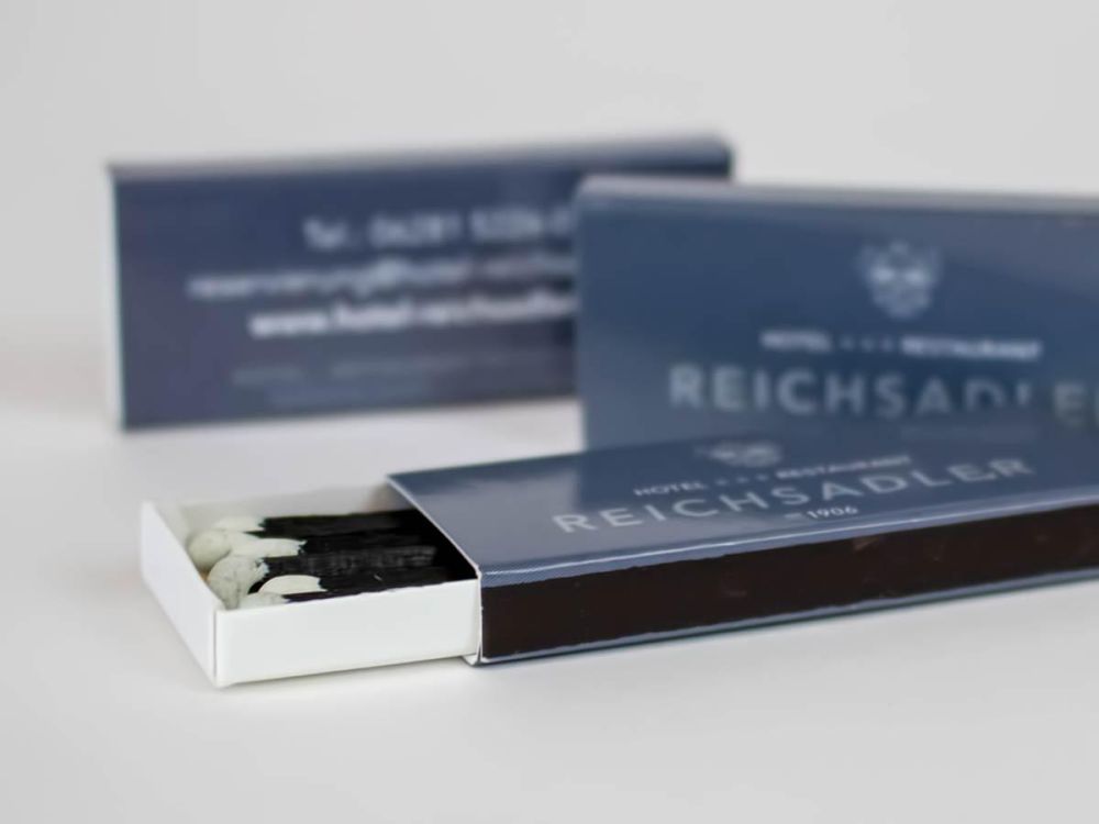 Schwarze Streichhölzer in der Verpackung in neuem Corporate Design