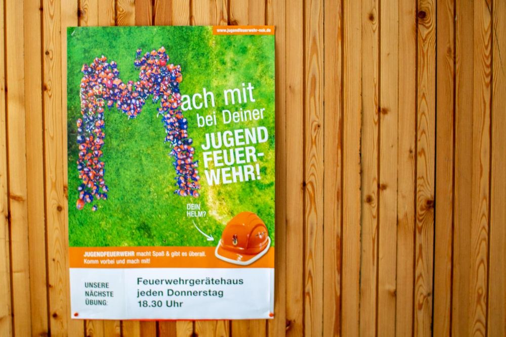 Plakat Mach mit bei deiner Jugendfeuerwehr auf einer Holzwand