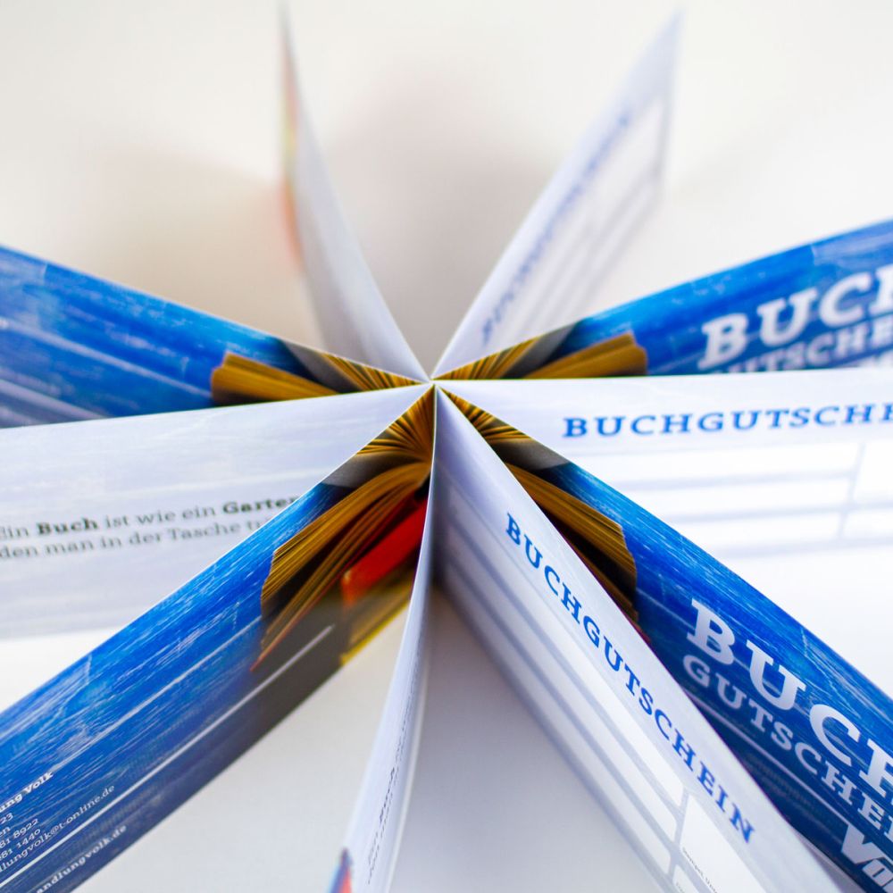 Mehrere Buchgutscheine sternförmig aufgestellt und von oben fotografiert