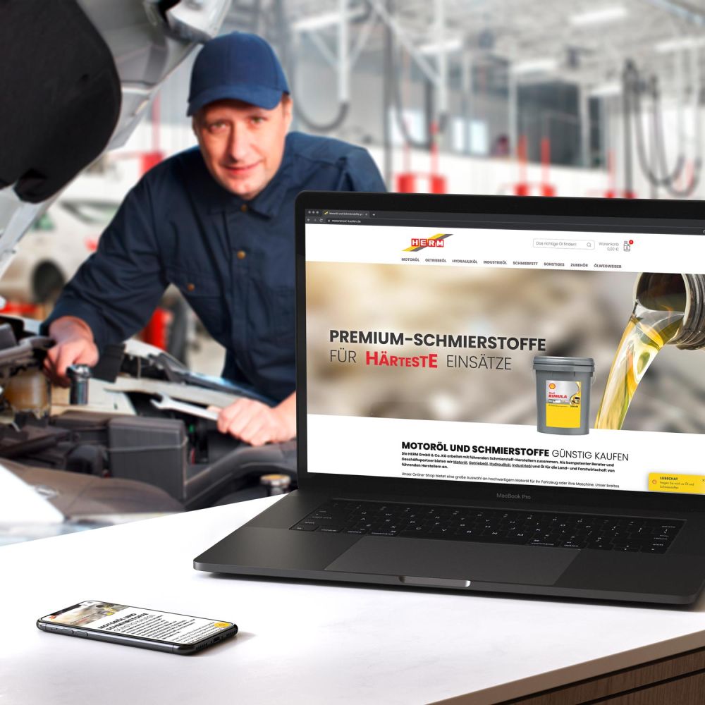 Offenes Laptop in einer AutoWerkstatt. Auf dem Laptop ist der HERM online Shop geöffnet.